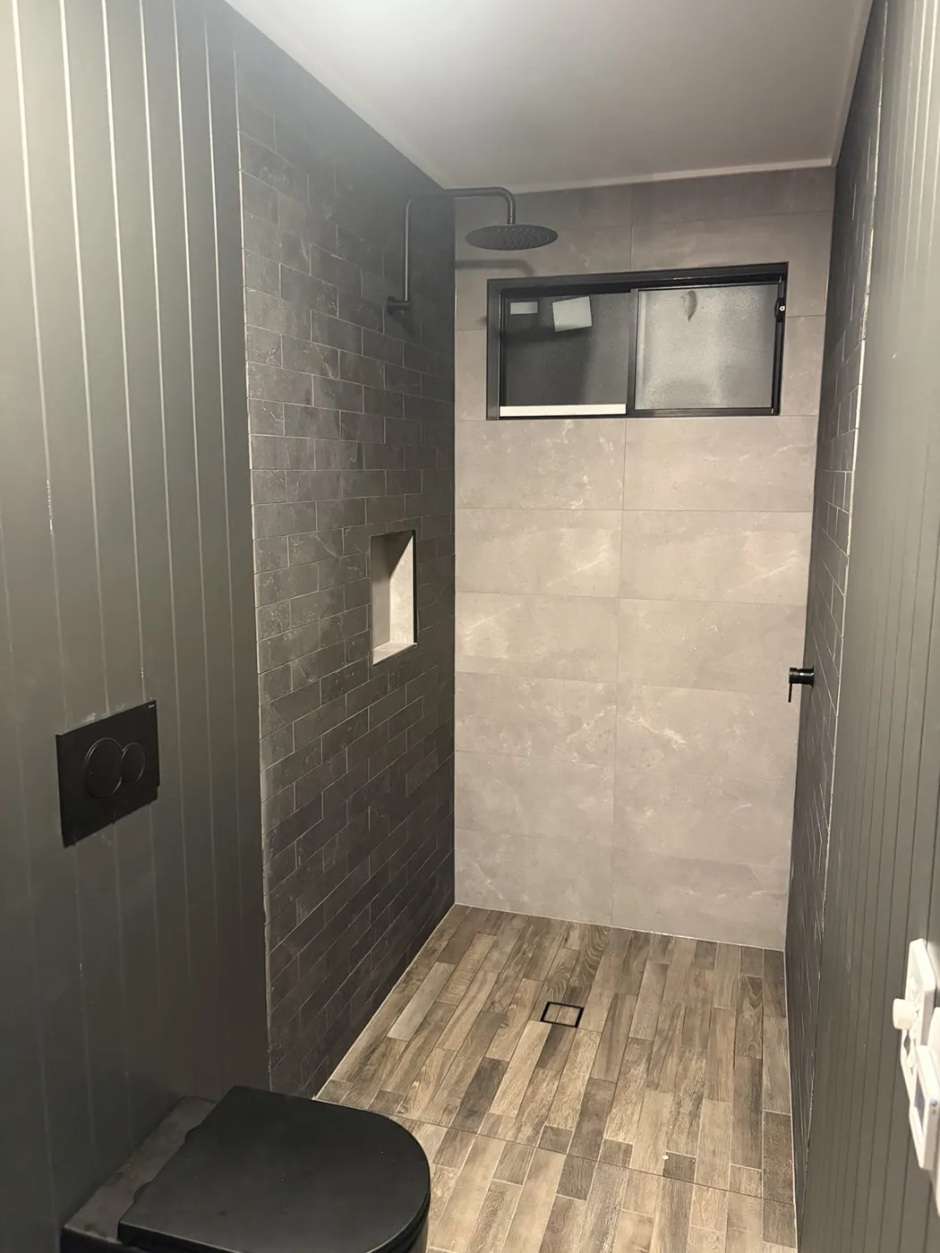 Tiled shower with niche and black fittings