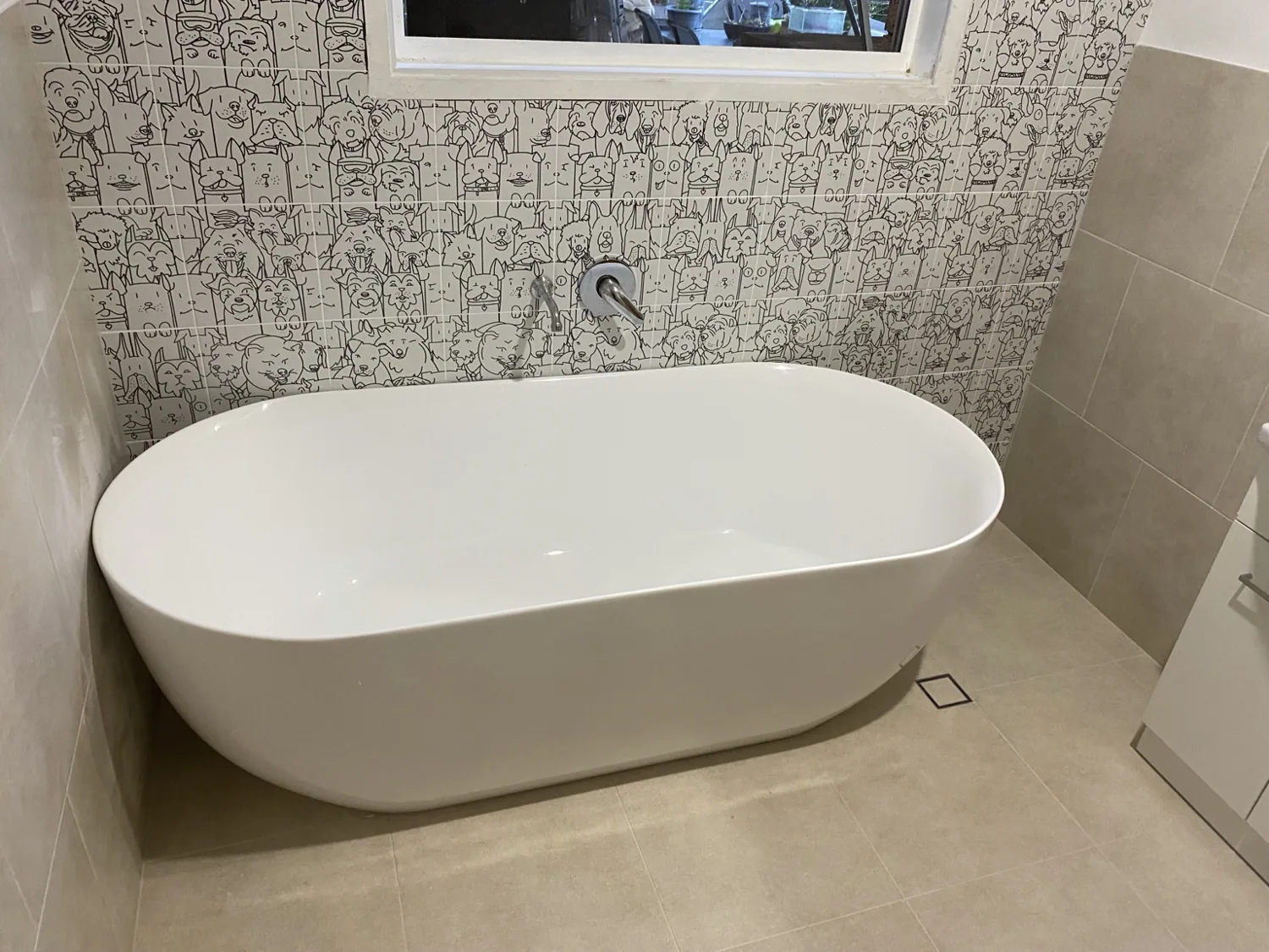Freestanding bath with patterned feature wall and floor waste